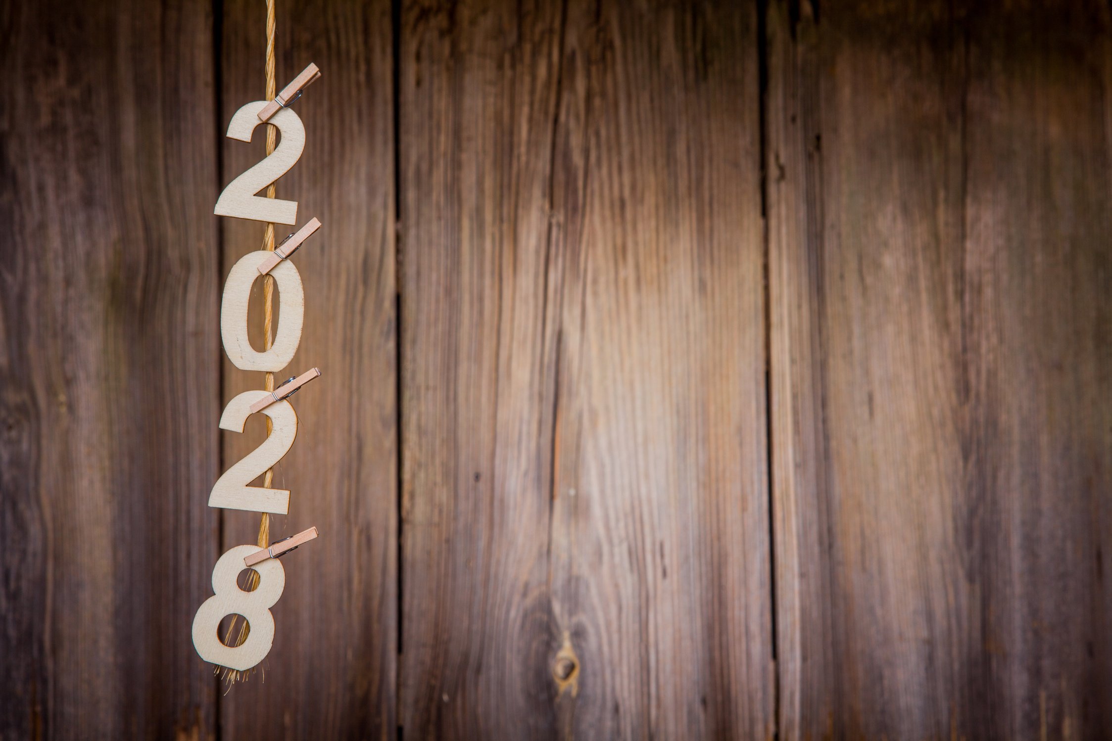 New Year's concepts 2028 cropped wooden numbers are hanging on a string on the background of old wood